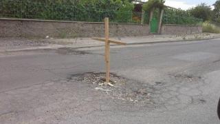 Дървен кръст пази шофьори от дупки