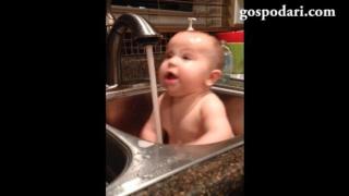 Бебе се къпе в мивка и се изненадва от течащата вода (ВИДЕО)