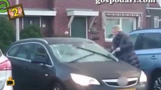 Блондинка чисти предното стъкло на колата си при работещи чистачки