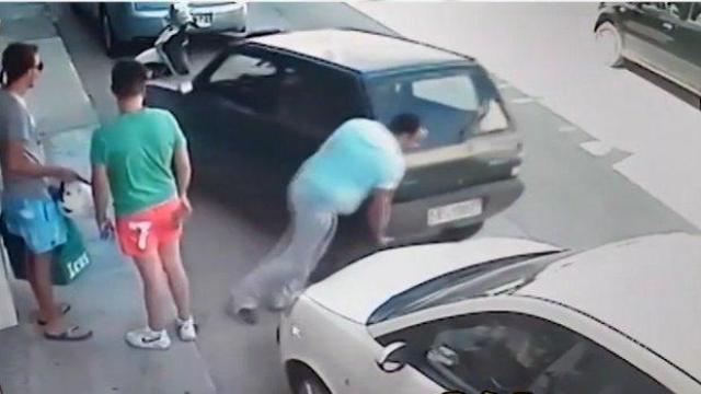 Мъж мести колата си с ръце, за да се измъкне от тясно място
