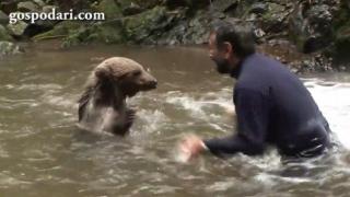 Мечка и човек се плискат с вода като истински приятели (ВИДЕО)