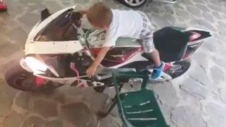 Малко момче не може да се качи на мотор, но умее да го запали