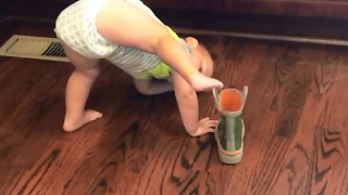 Бебе опитва да обуе ботуш по много забавен начин (видео)