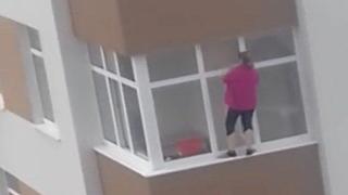 Домакиня мие прозорци на голяма височина без предпазни въжета (видео)