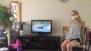 Снимка на вързана жена със запушена уста, докато съпругът ѝ гледа рали, скандализира интернет