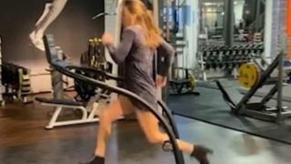 Фитнес маниачка бяга на пътеката с високи токчета и рокля (видео)