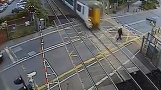 Безразсъден пешеходец се размина на косъм с профучаващ влак, след като премина през спуснатата бариера  (видео и снимки)