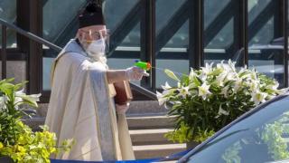 Свещеник пръска светена вода с детски пистолет заради социалната дистанция (видео и снимки)