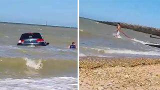 Мъж отчаяно се бори да извади колата си от морето, след като вълните я отнесоха навътре (видео и снимки)