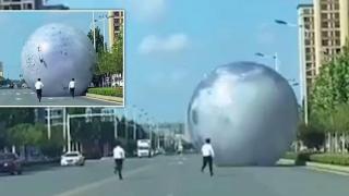 Гигантска надуваема луна се търкулна по  улица, паникьосани служители я гонят