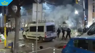 Тежки сблъсъци пред централите на ГЕРБ и ДПС: бомбички, горящи кофи и счупен полицейски бус (видео)